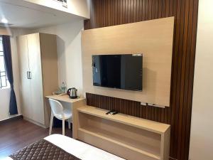 a hotel room with a television on a wall at Niki Inn in Pondicherry