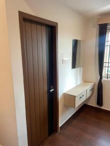 a door in a room with a tv and a desk at Niki Inn in Pondicherry
