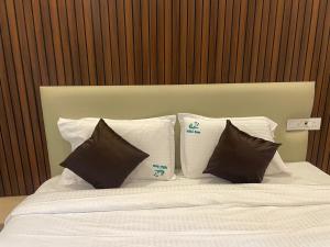 a bed with four pillows on top of it at Niki Inn in Pondicherry