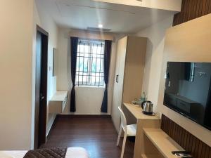 a small room with a bedroom with a television at Niki Inn in Pondicherry