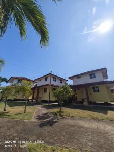 a group of buildings with trees and a palm tree at Chalet Kurung Tengar in Kuala Perlis