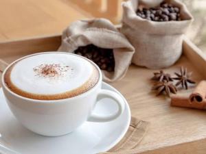 a cup of coffee on a table with coffee beans at Suites Confort Paris & Orly in Villeneuve-Saint-Georges +2 photos