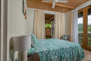 a bedroom with a bed and a balcony at Tipani Villa Sovereign Palms CI in Rarotonga