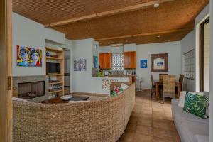 a living room with a couch and a dining room at Tipani Villa Sovereign Palms CI in Rarotonga