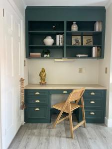 a green desk with a chair in a room at The Tamara Suite in Pensacola