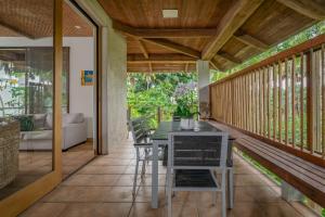 a dining room with a table and chairs on a balcony at Tipani Villa Sovereign Palms CI in Rarotonga