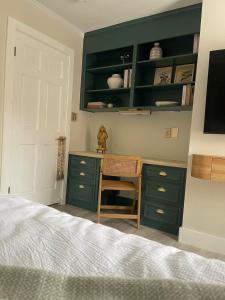 a bedroom with green cabinets and a desk with a bed at The Tamara Suite in Pensacola +19 photos