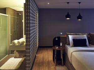 a bedroom with a large bed and a shower at Grand Mercure Brasilia Eixo Monumental in Brasília