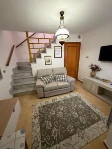 a living room with a couch and a staircase at CA'da LU' in Velva