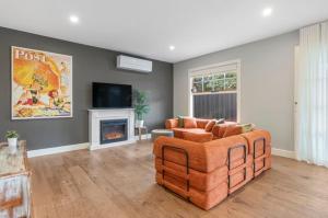 a living room with a couch and a fireplace at Peninsula Green Cottage for 14 guests in Capel Sound
