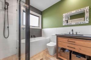 a bathroom with a toilet and a sink and a bath tub at Peninsula Green Cottage for 14 guests in Capel Sound +28 photos