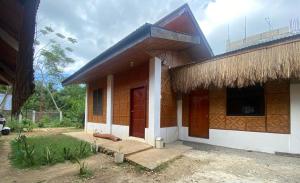 a house with a thatched roof and a porch at Be My Guest Hostel in Panglao Island