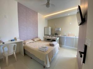 a small room with a bed and a kitchen at Hotel kitnet Digital in Passos