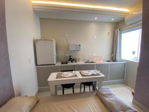 a small kitchen with a table and a sink at Hotel kitnet Digital in Passos +122 photos
