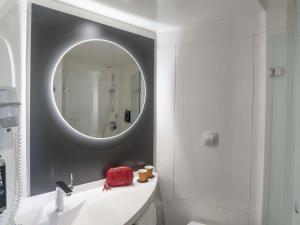 a bathroom with a mirror and a white sink at Ibis Barcelona Aeropuerto Viladecans in Viladecáns +45 photos