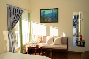 a living room with a couch and a large window at Mộc Villa DaLat in Khu Chi Lăng