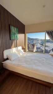 a bedroom with a large bed with a large window at Mộc Villa DaLat in Khu Chi Lăng