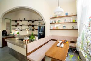 a kitchen with a bench and a table and shelves at Mộc Villa DaLat in Khu Chi Lăng