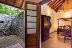 una puerta que conduce a una habitación con una pared de piedra en The Kandyan Manor by Bhathiya & Suzy, en Kandy