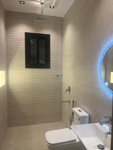 a bathroom with a shower with a toilet and a sink at شاليه اغصان الباحة in Al Baha