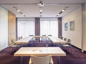 a conference room with tables and chairs and windows at Sunday Hotel Düsseldorf City Nord in Düsseldorf