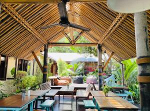 an outdoor patio with wooden tables and chairs at Aha Lanta Cozy Hostel in Ko Lanta