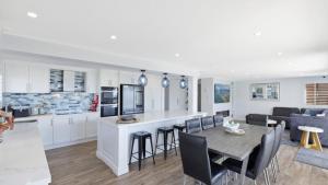 a kitchen and living room with a table and chairs at Avoca Dream in Avoca Beach