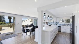 a kitchen and dining room with a table and chairs at Avoca Dream in Avoca Beach