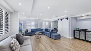a living room with a blue couch and a table at Avoca Dream in Avoca Beach