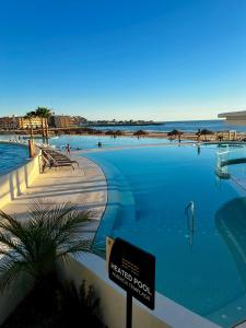 a swimming pool with a sign in front of the ocean at Sonoran Star Luxury 3 Bedroom Breachfront Condominium in Puerto Peñasco