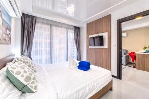 a bedroom with a large bed with a blue bag on it at LUMA Condo 1BR Open View NBC Nai Harn in Rawai Beach