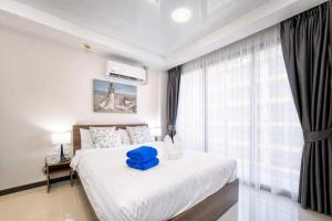a bedroom with a large bed with a blue stool on it at LUMA Condo 1BR Open View NBC Nai Harn in Rawai Beach