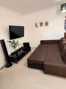 a living room with a couch and a flat screen tv at Bellomar I Exclusive Juan Dolio Playa Hemingway in Juan Dolio