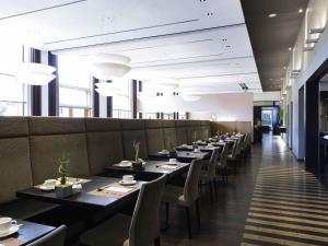 a row of tables and chairs in a restaurant at Novotel Karlsruhe City in Karlsruhe