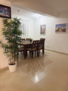 a dining room with a table and chairs and a plant at Bellomar I Exclusive Juan Dolio Playa Hemingway in Juan Dolio