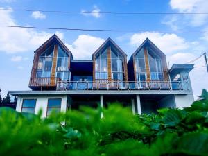 a house with a balcony on top of it at Glamping Dieng New in Diyeng