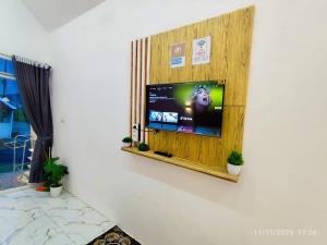 a flat screen tv on a wall in a room at Glamping Dieng New in Diyeng