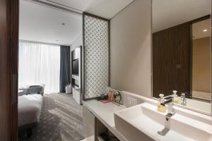 a bathroom with a sink and a large mirror at Hotel Gracery Seoul in Seoul +70 photos