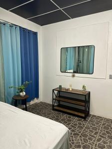 a bedroom with blue curtains and a bed and a mirror at Asha Hostel in Fortuna +45 photos