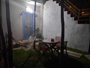 a patio with a table and chairs and a hammock at ViRa Farm in Sūlagiri