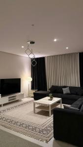 a living room with a couch and a tv at الواحه ريزدنس in Medina