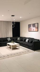 a living room with a black couch and a table at الواحه ريزدنس in Medina