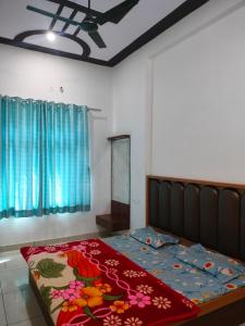 a bedroom with a bed with a colorful blanket on it at Keshav guest house in Rīngas