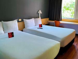 a hotel room with two beds and a chair at Ibis Mexico Perinorte in Mexico City +47 photos