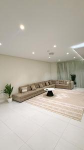 a living room with a couch and a table at الواحه ريزدنس in Medina +20 photos