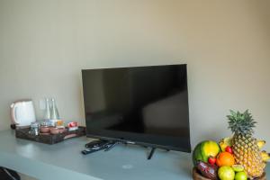 a flat screen tv sitting on a table with fruit at Petti Petti Beach Club- Mirissa in Mirissa