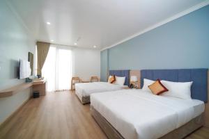 a hotel room with two beds and a television at Eden Luxury Hotel in Thái Bình