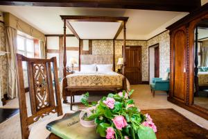 1 dormitorio con 1 cama y 1 mesa con flores en Soulton Hall, en Wem
