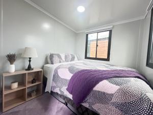 a bedroom with a bed and a window at Alpaca Haven Farm in Rotorua