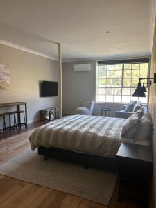 a bedroom with a bed and a desk and a television at Gala 1 - The Old Coolstore in Merricks North